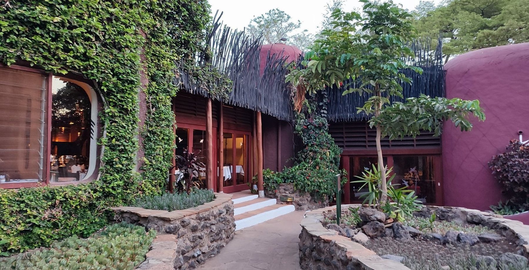 Path and steps leading to the creeper-covered, red-walled buildings of Amboseli Serena Safari Lodge