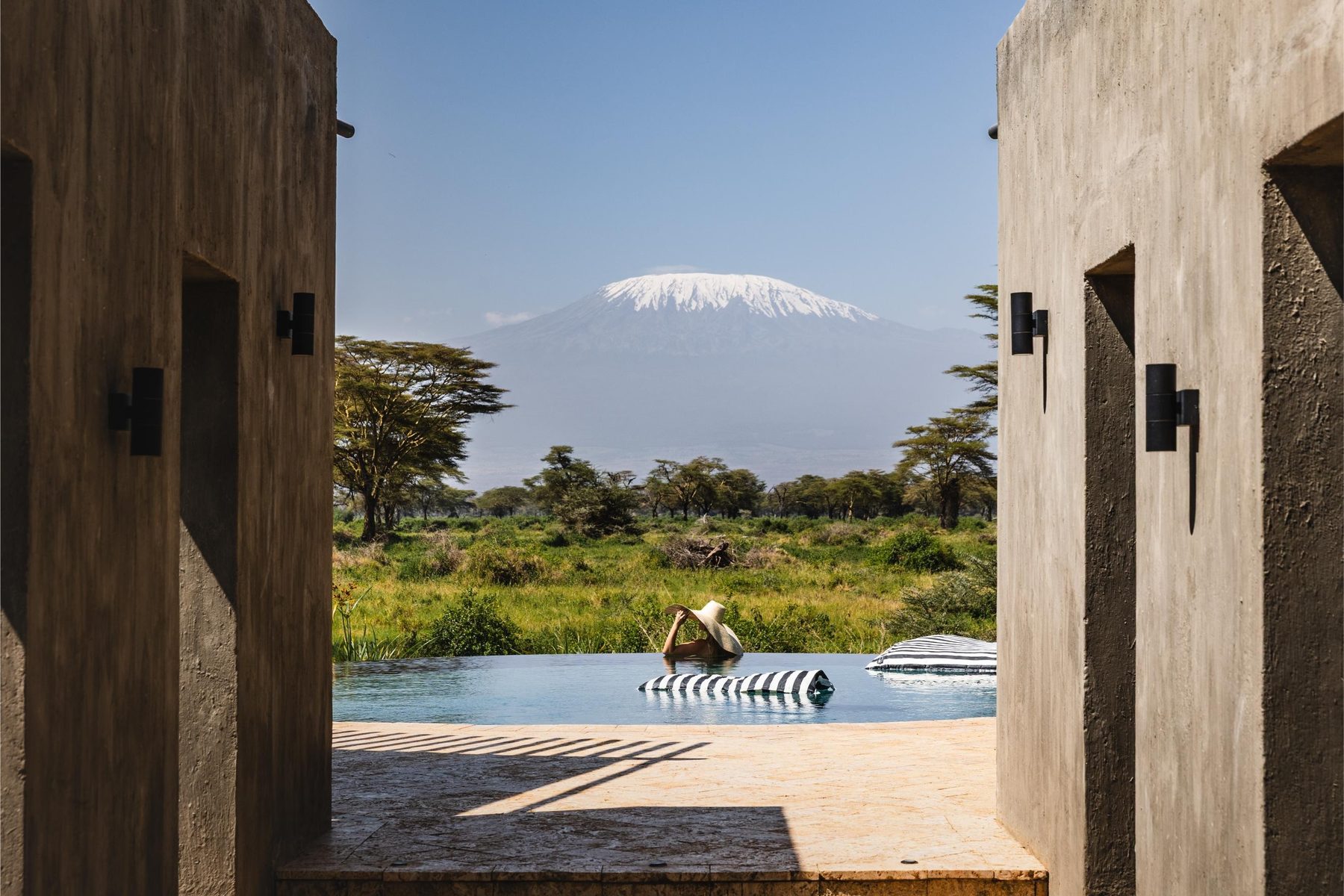 Pool framed by two stone walls at Angama Amboseli, with snow-capped Kilimanjaro rising beyond