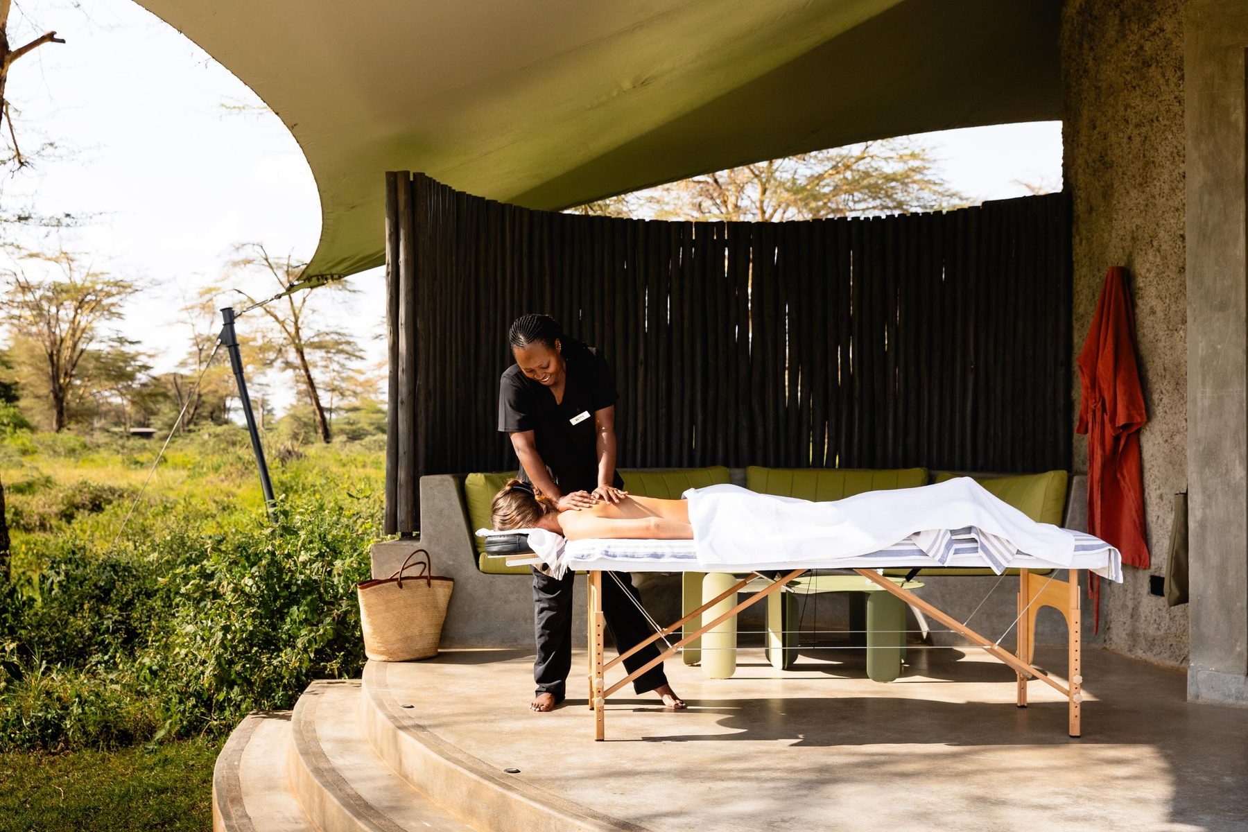 Massage under a thatched shelter open to the bush at the spa at Angama Amboseli