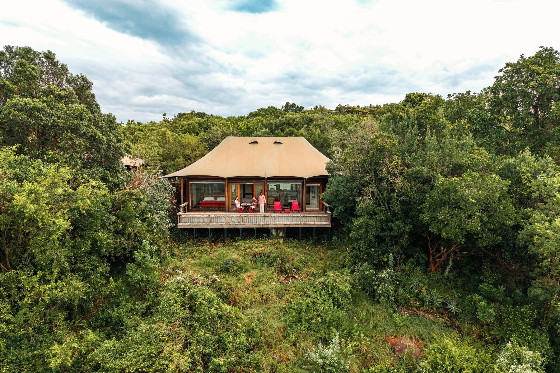 Tented suite with a canvas roof and deck tucked into thick green forest at Angama Mara