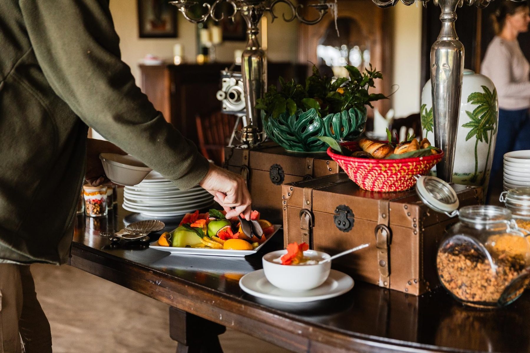 Breakfast laid out on a wooden sideboard with fruit, cereals and silverware at Cottar’s 1920s Camp