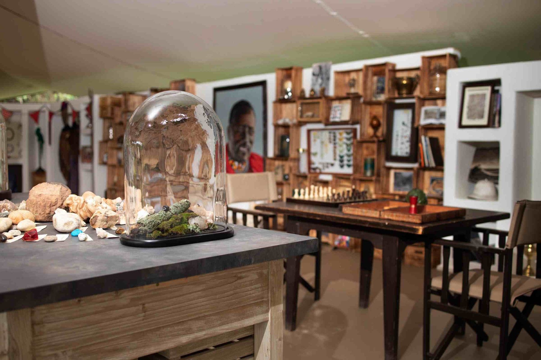 Library at Cottar’s 1920s Camp with a glass dome over curios, shelves of books and a writing desk