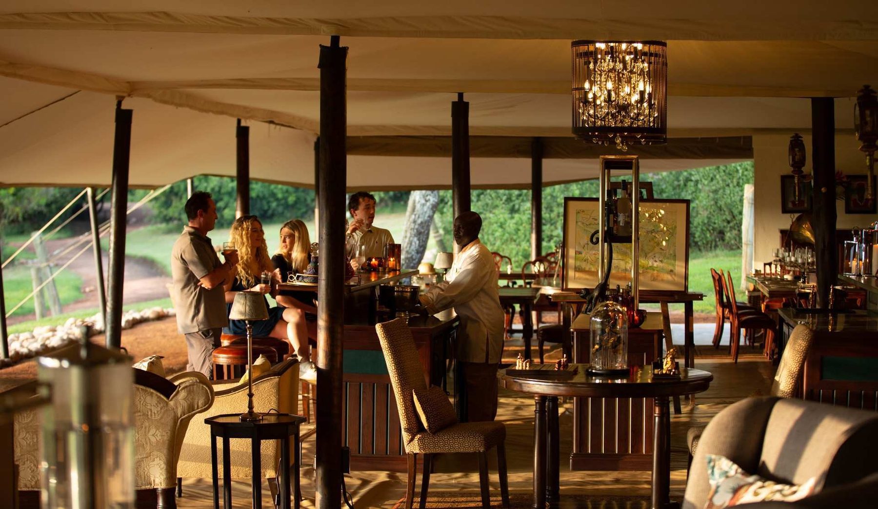 Guests gathered in the main tent at Cottar’s 1920s Camp, with chandeliers, dining tables and armchairs