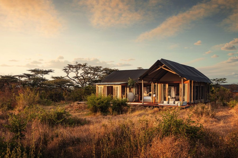 Tented suite with a covered deck among acacia trees and dry grass at JW Marriott Mount Kenya Rhino Reserve Safari Camp