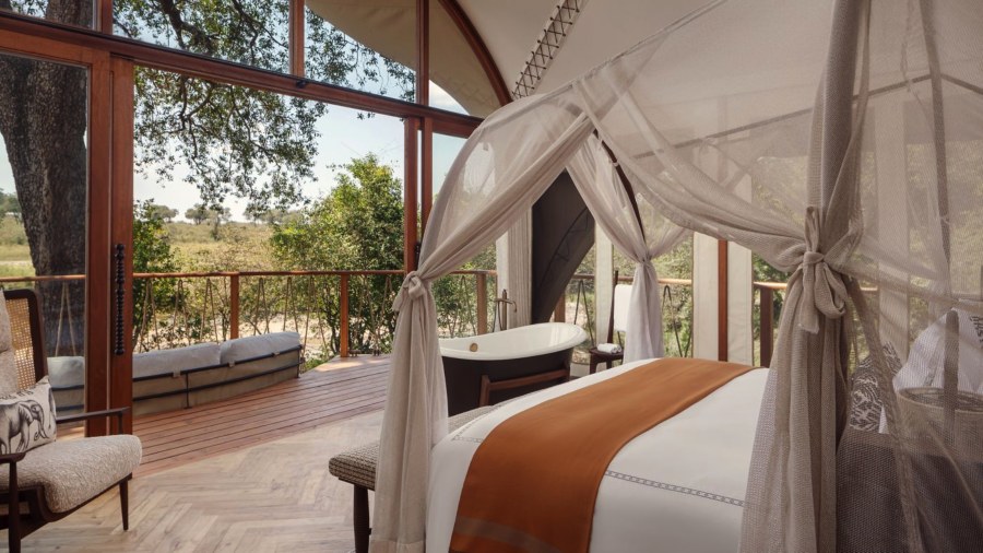Tented suite at The Ritz-Carlton, Masai Mara Safari Camp with a netted bed and a freestanding bath on the deck