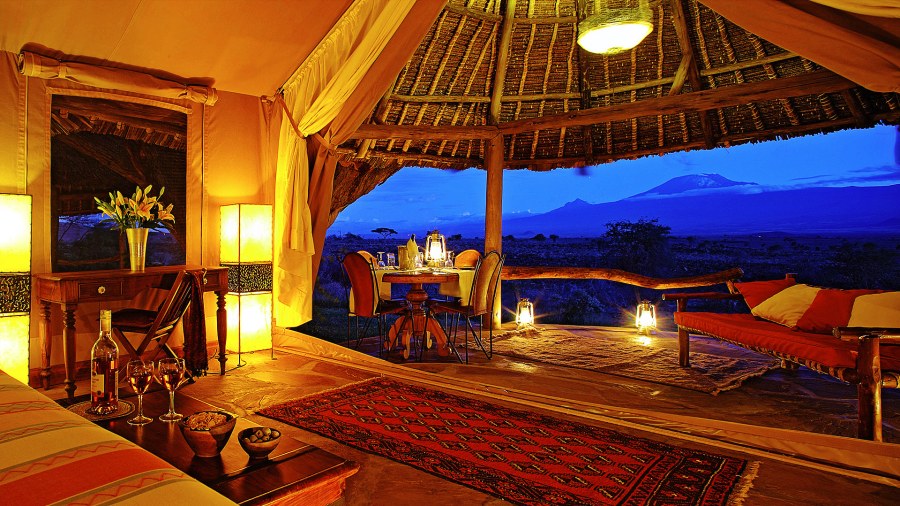 Open-sided tent with a table for two facing Kilimanjaro at dusk at Elewana Tortilis Camp Amboseli