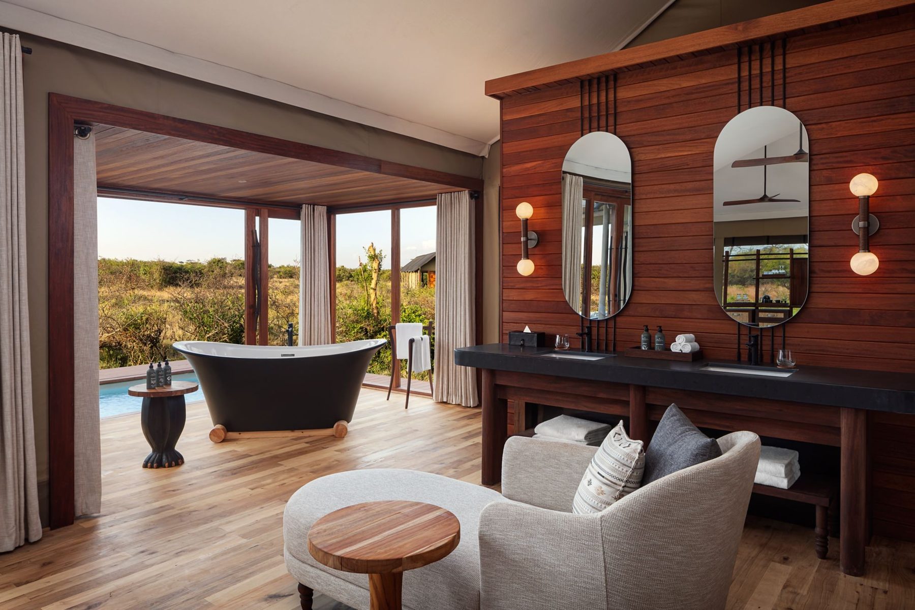 Suite bathroom at JW Marriott Mount Kenya Rhino Reserve Safari Camp with a freestanding bath, twin basins and timber walls