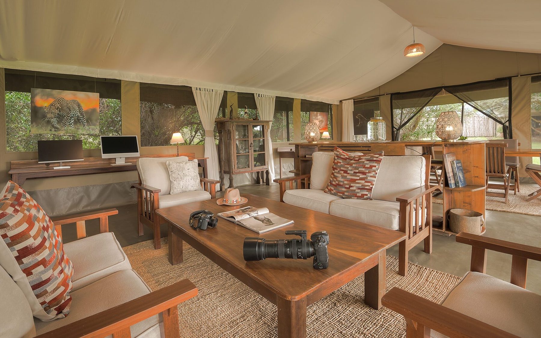 Lounge tent at Kicheche Mara North with sofas, patterned cushions, a coffee table and books