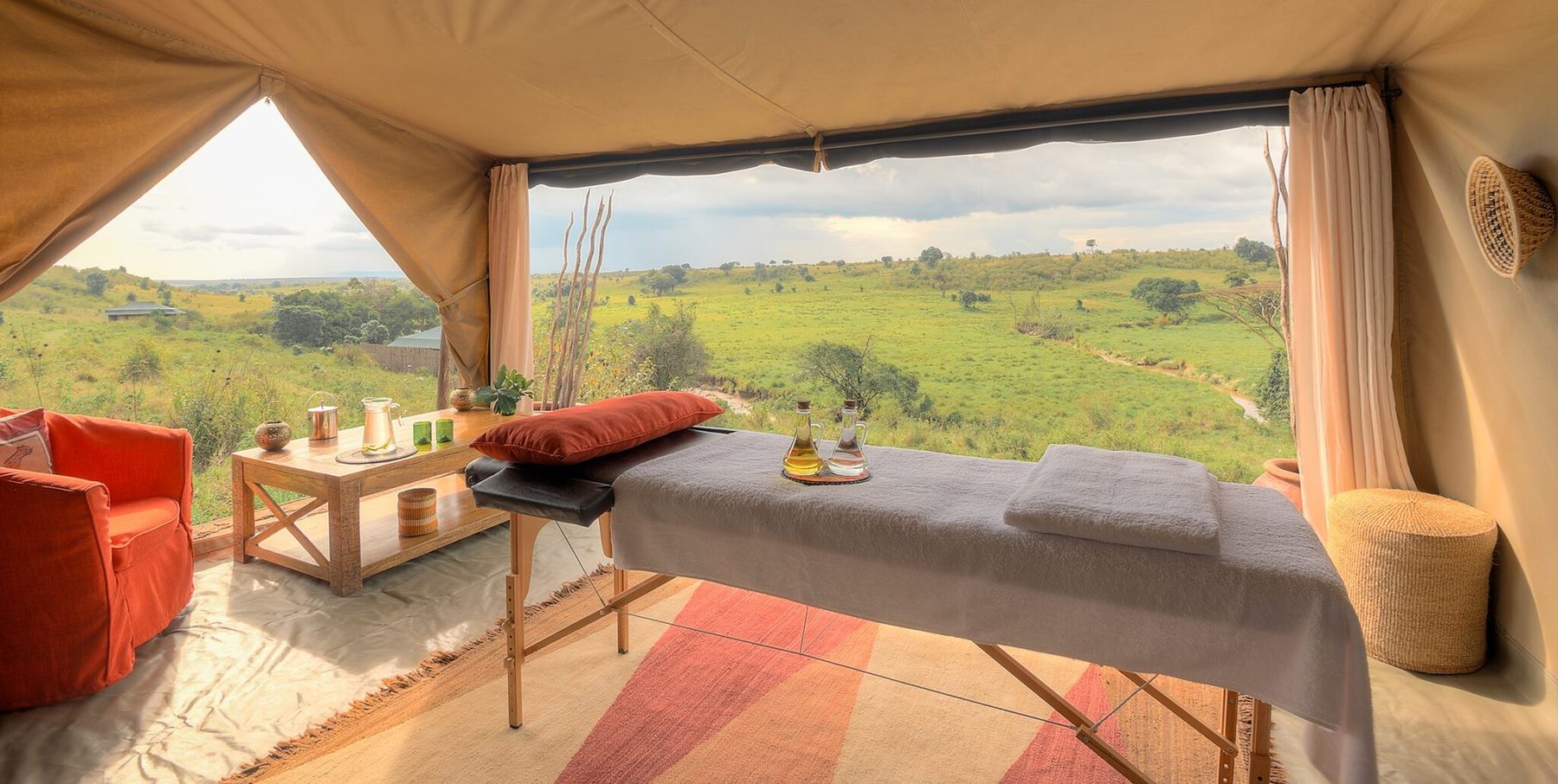 Massage table in a tent at Kicheche Mara North, rolled up sides opening to green hills