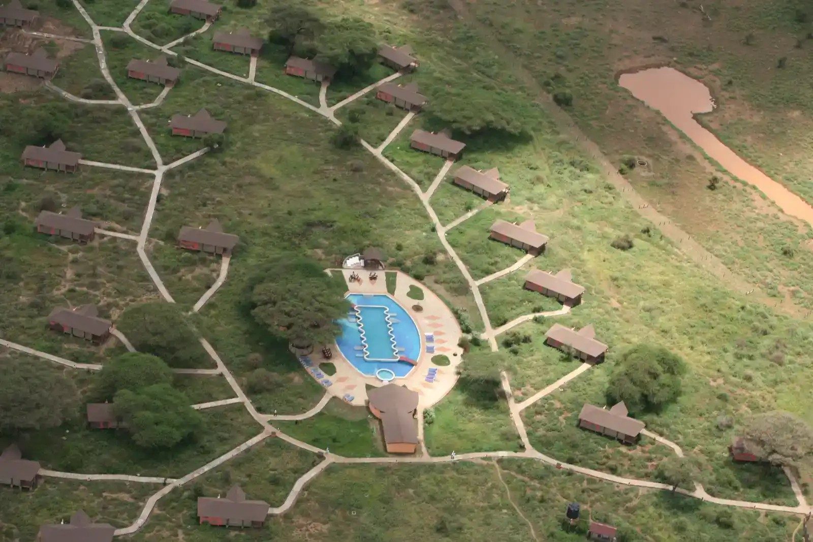 Aerial view of Kilima Safari Camp, with tents linked by winding paths around a central swimming pool