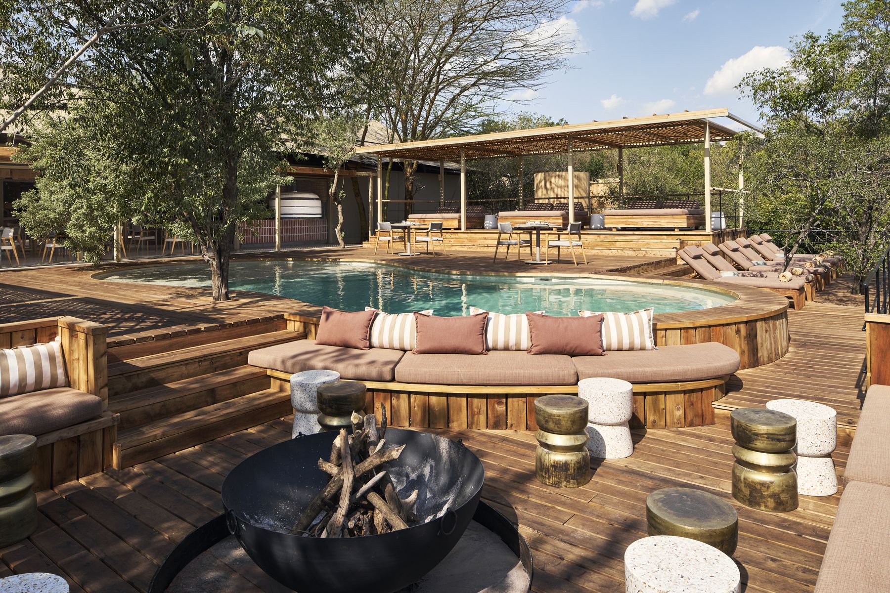 Kinara’s pool and sun deck, with cushioned seating around a fire pit in the foreground
