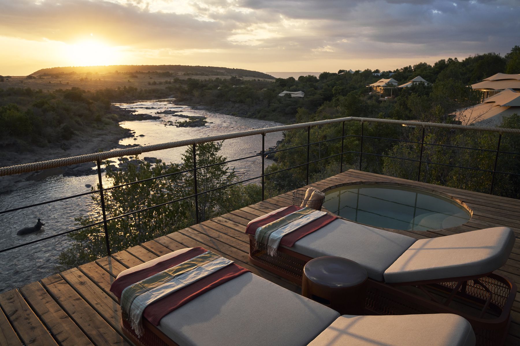 Two loungers beside a plunge pool on a suite deck at Kinara, above the Mara River at sunset