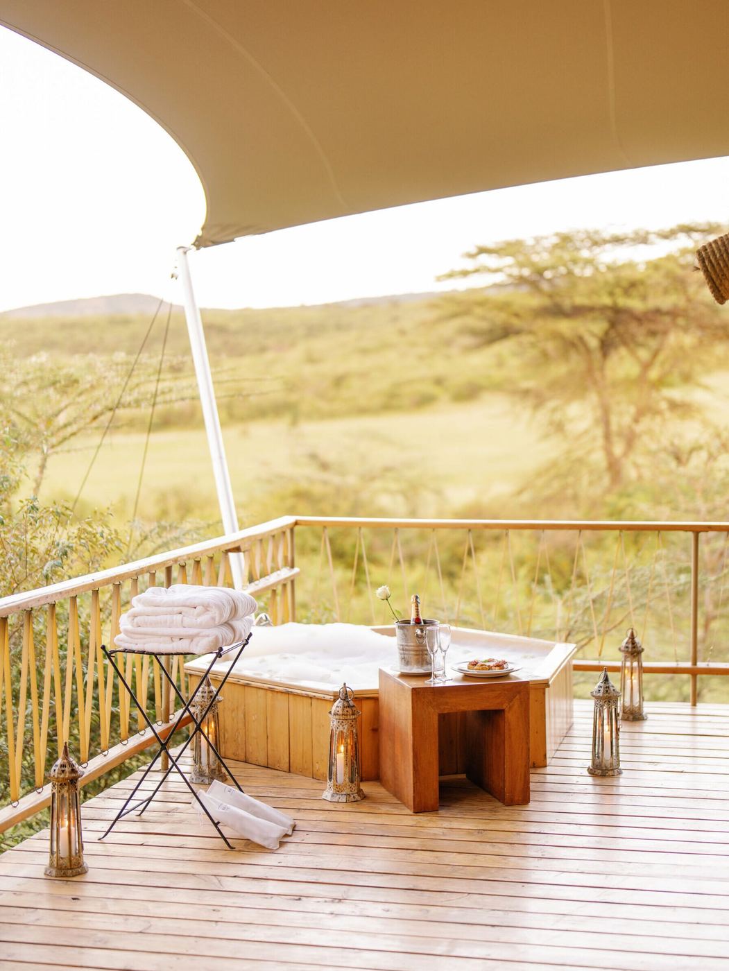 Wooden hot tub with towels and champagne on a suite deck at Mara Bushtops, overlooking the plains