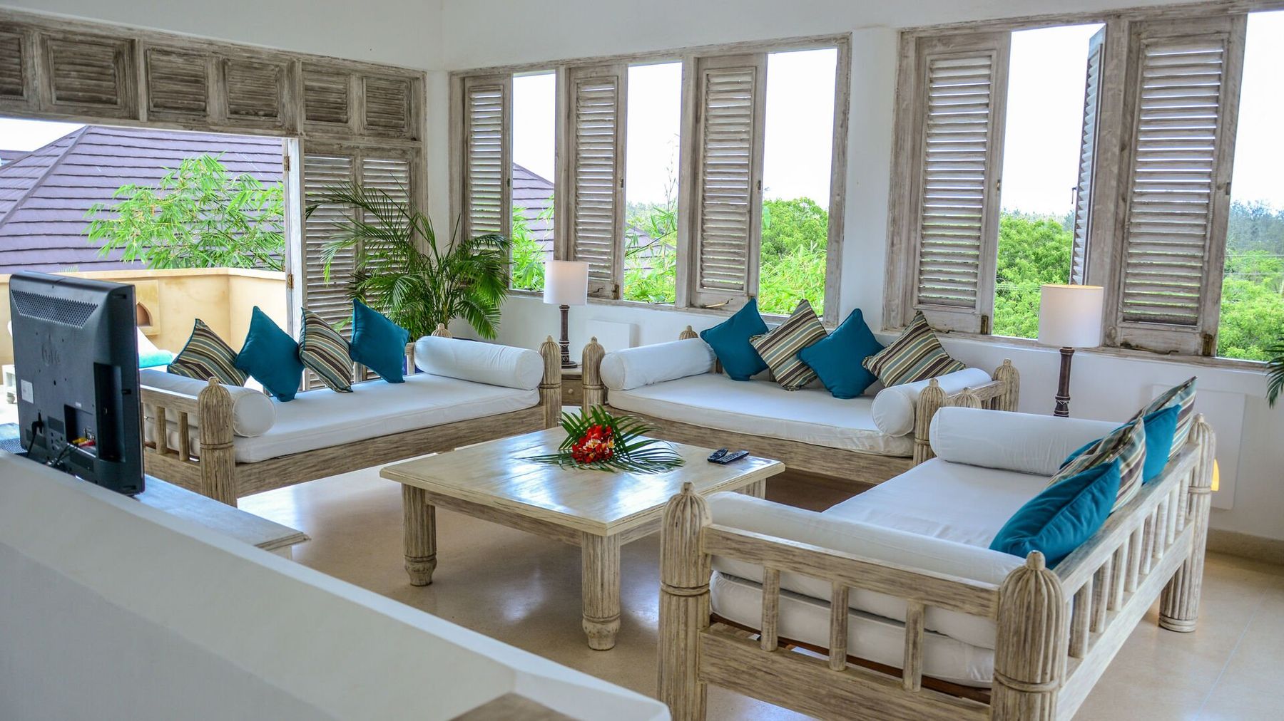 A bright lounge at Medina Palms with white sofas, blue cushions and wooden shutters