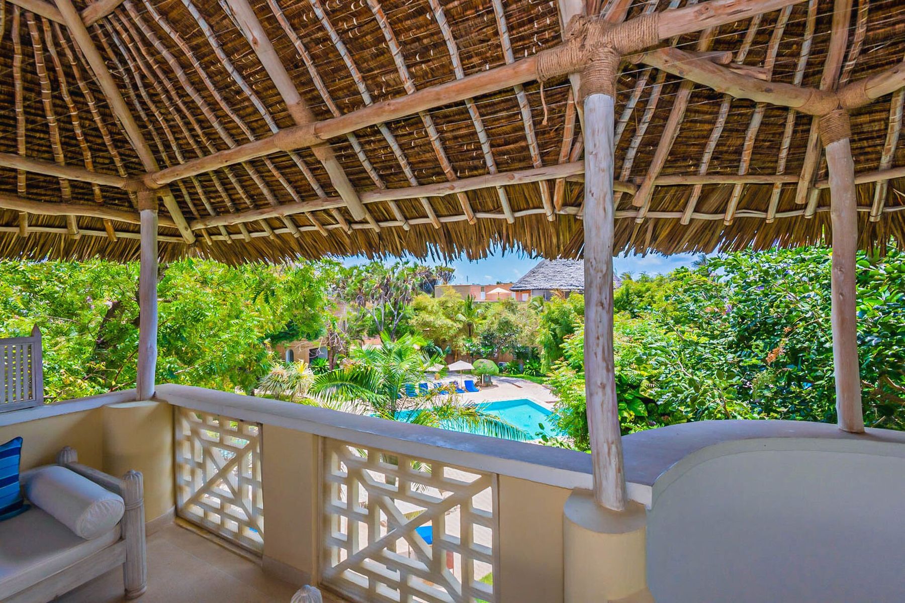 View from a thatched rooftop terrace at Medina Palms over gardens and a pool