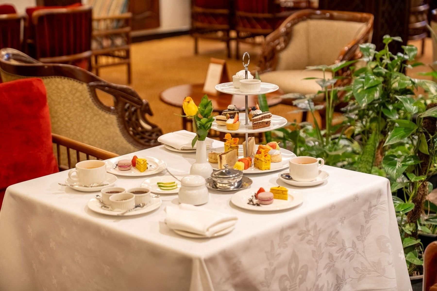 Afternoon tea with a cake stand and china cups on a white tablecloth at Nairobi Serena Hotel