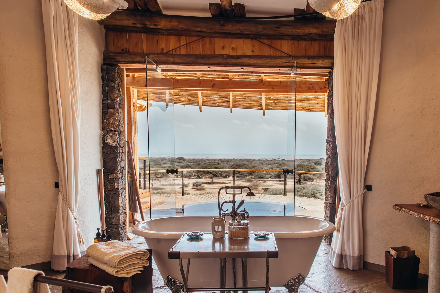 Freestanding bathtub before a wide open window onto the bush in a suite bathroom at ol Donyo Lodge