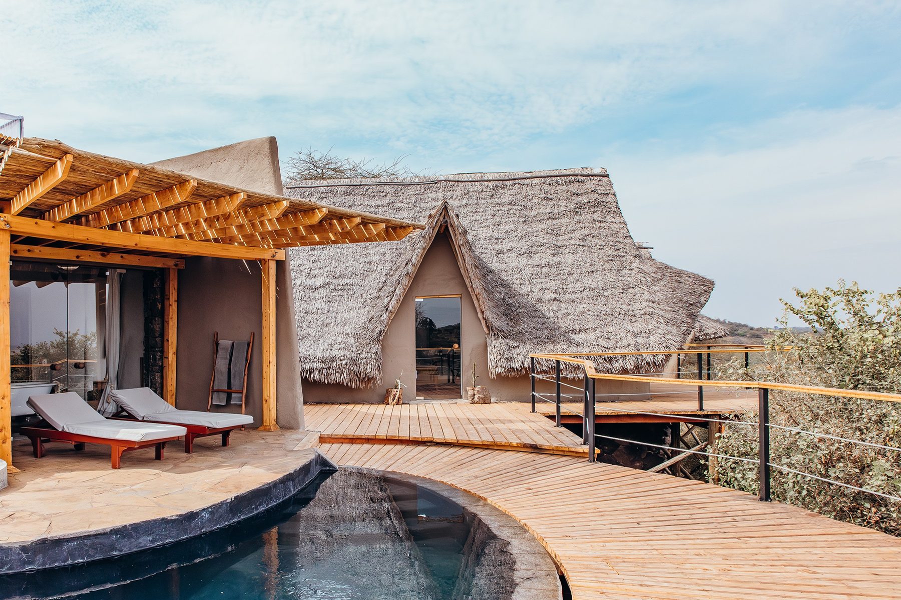 Thatched suite at ol Donyo Lodge with a private plunge pool and loungers on a wooden deck