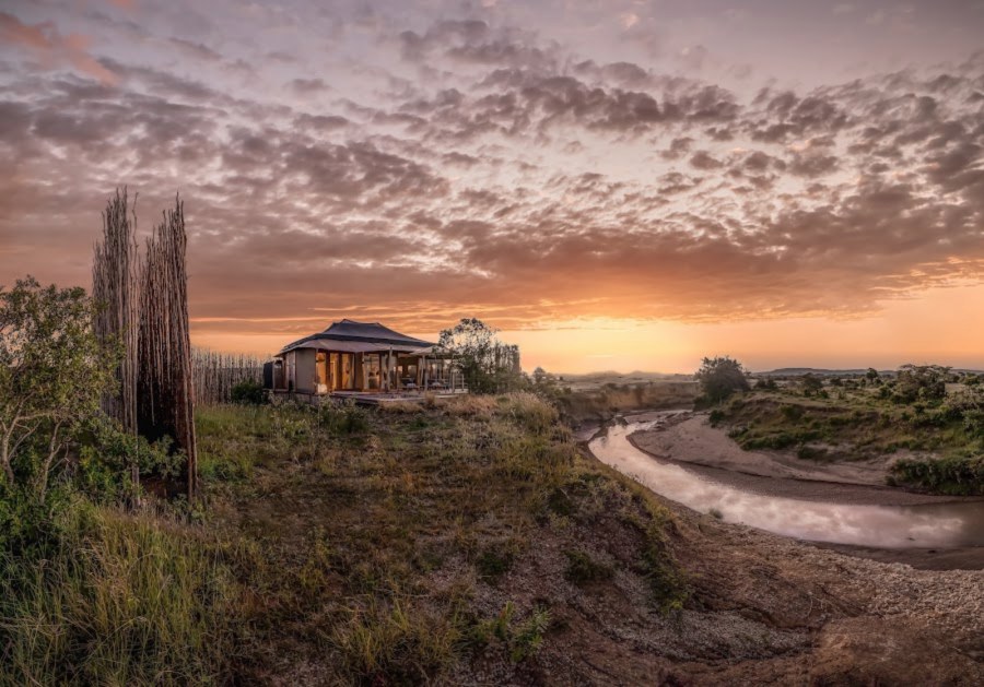 Tented suite on a grassy bank above a bend in the Talek River at sunrise at JW Marriott Masai Mara Lodge