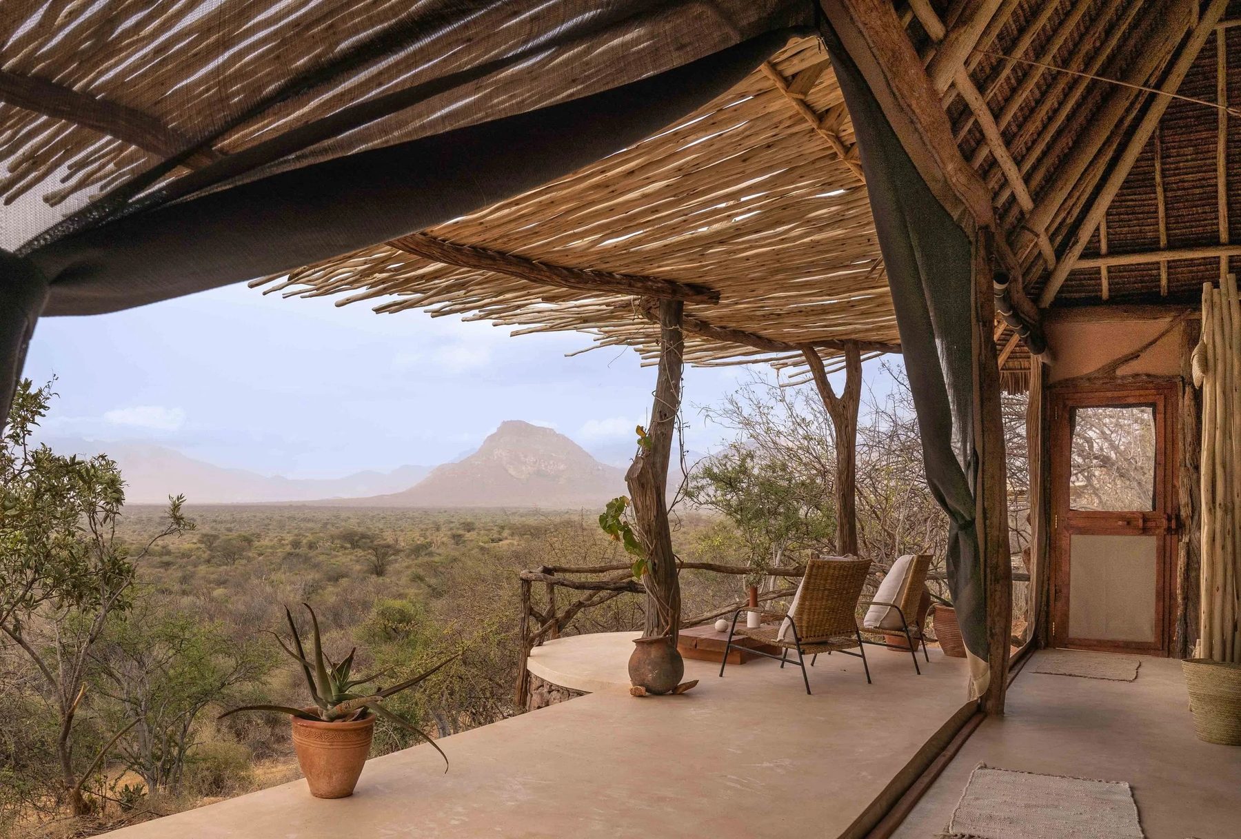 Shaded veranda outside a room at Reteti House, looking out over the bush to a distant peak