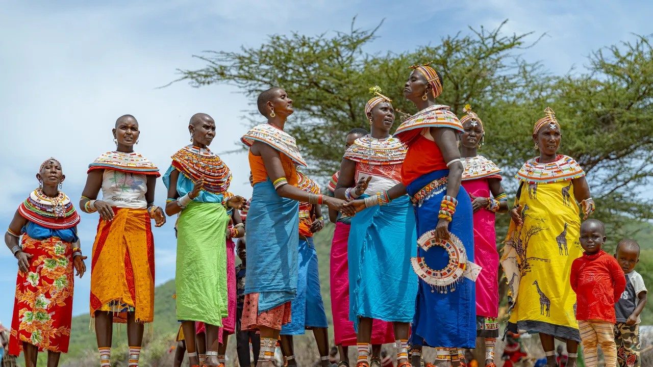Samburu women in bright beaded collars and wraps singing together near Samburu Intrepids