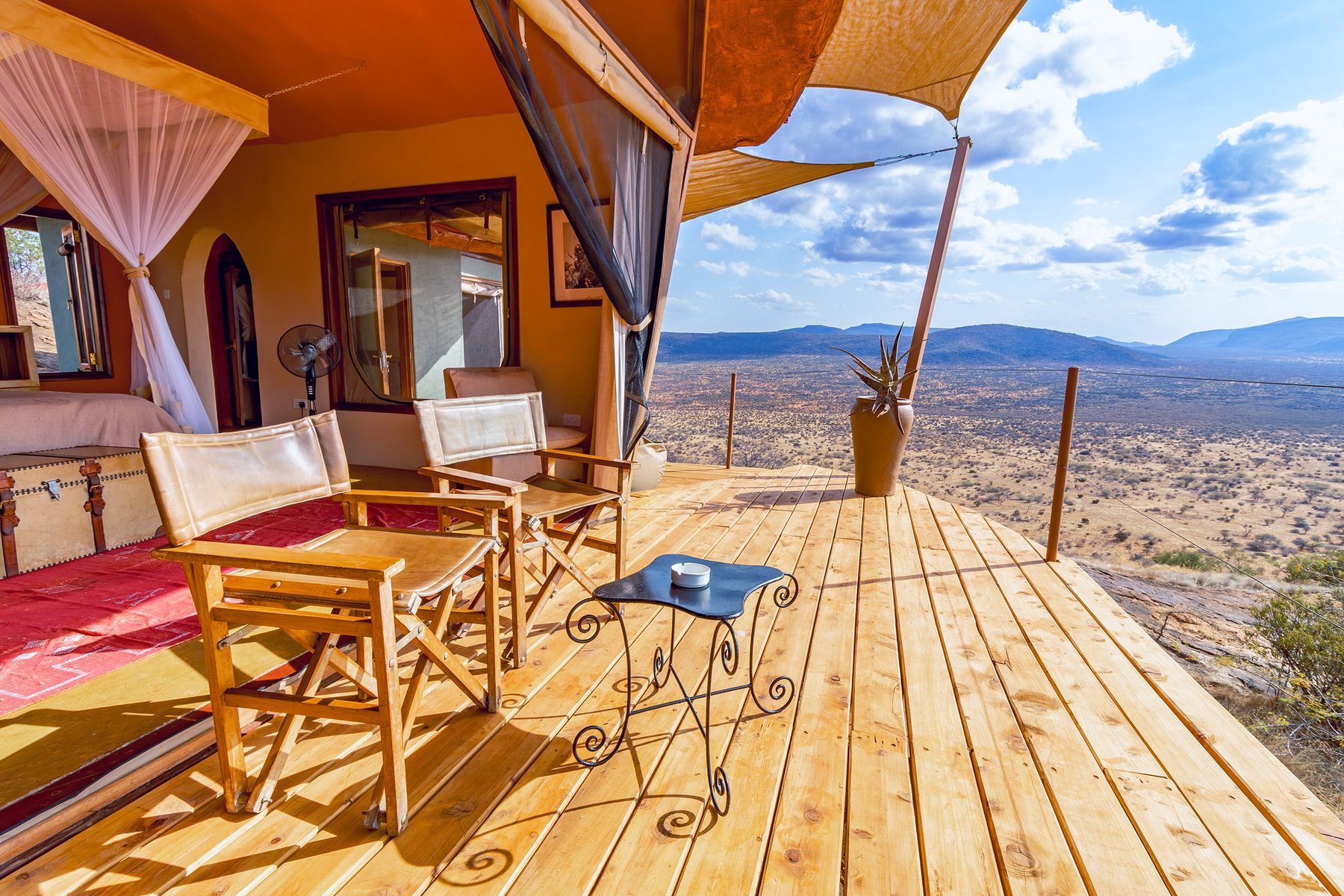 Wooden deck with canvas chairs outside a villa at Saruni Samburu, overlooking a wide dry valley