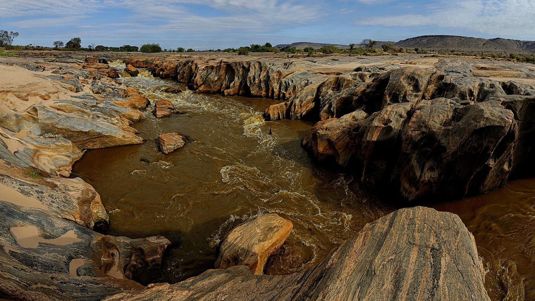 River running through a gorge of smooth rocks in Tsavo East National Park