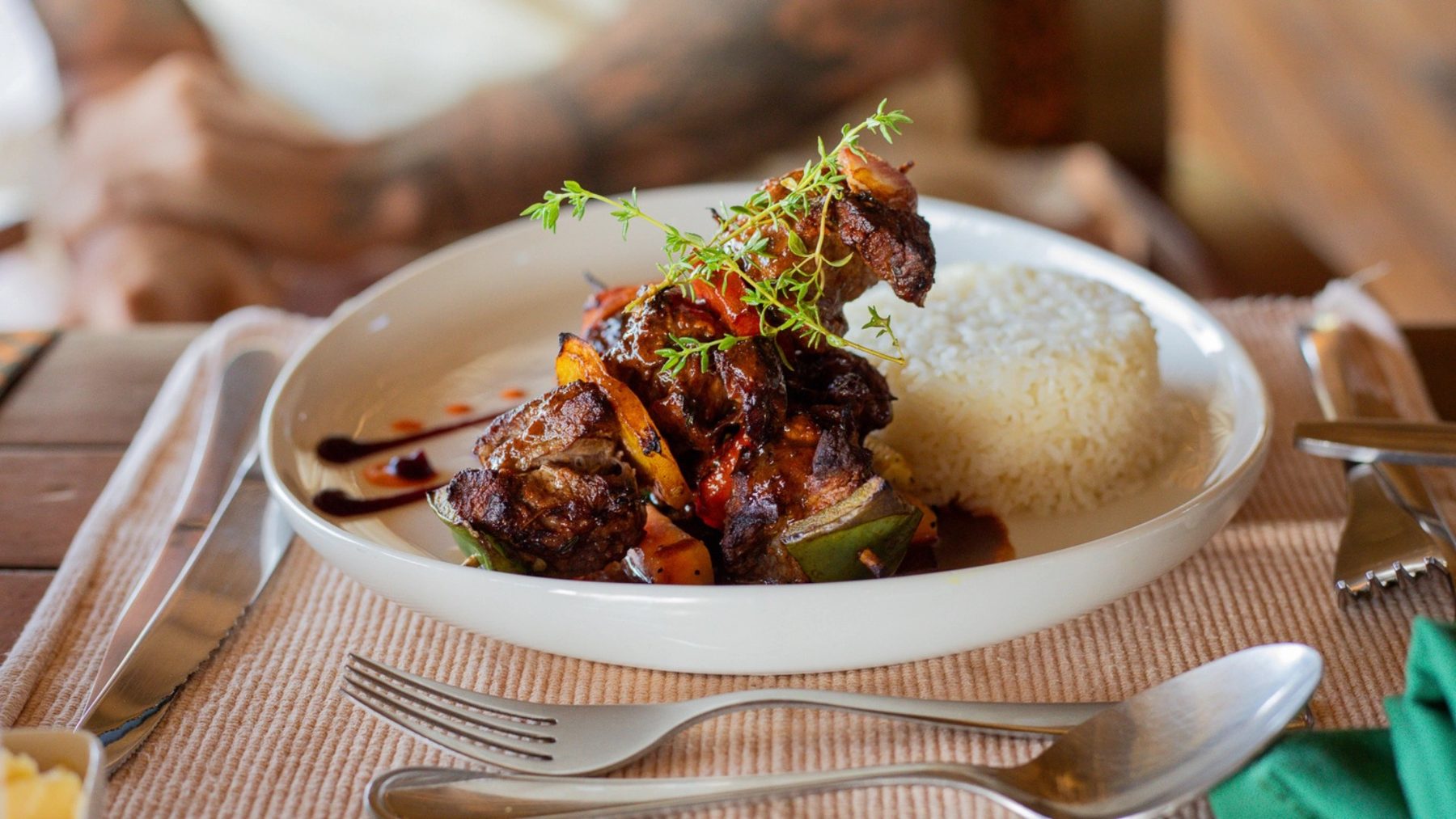 Plated main course of meat with rice and herbs on a dining table at Soroi Cheetah Tented Camp