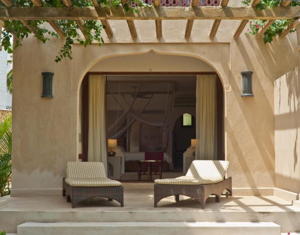 Arched terrace with two loungers under a pergola outside a room at Swahili Beach Resort