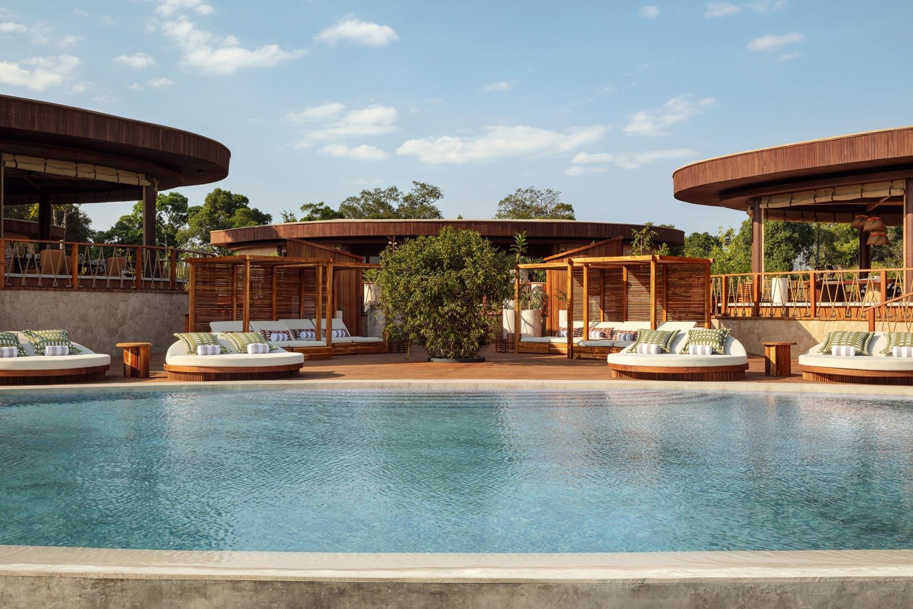 Main swimming pool at The Ritz-Carlton, Masai Mara Safari Camp, ringed by daybeds and timber pavilions