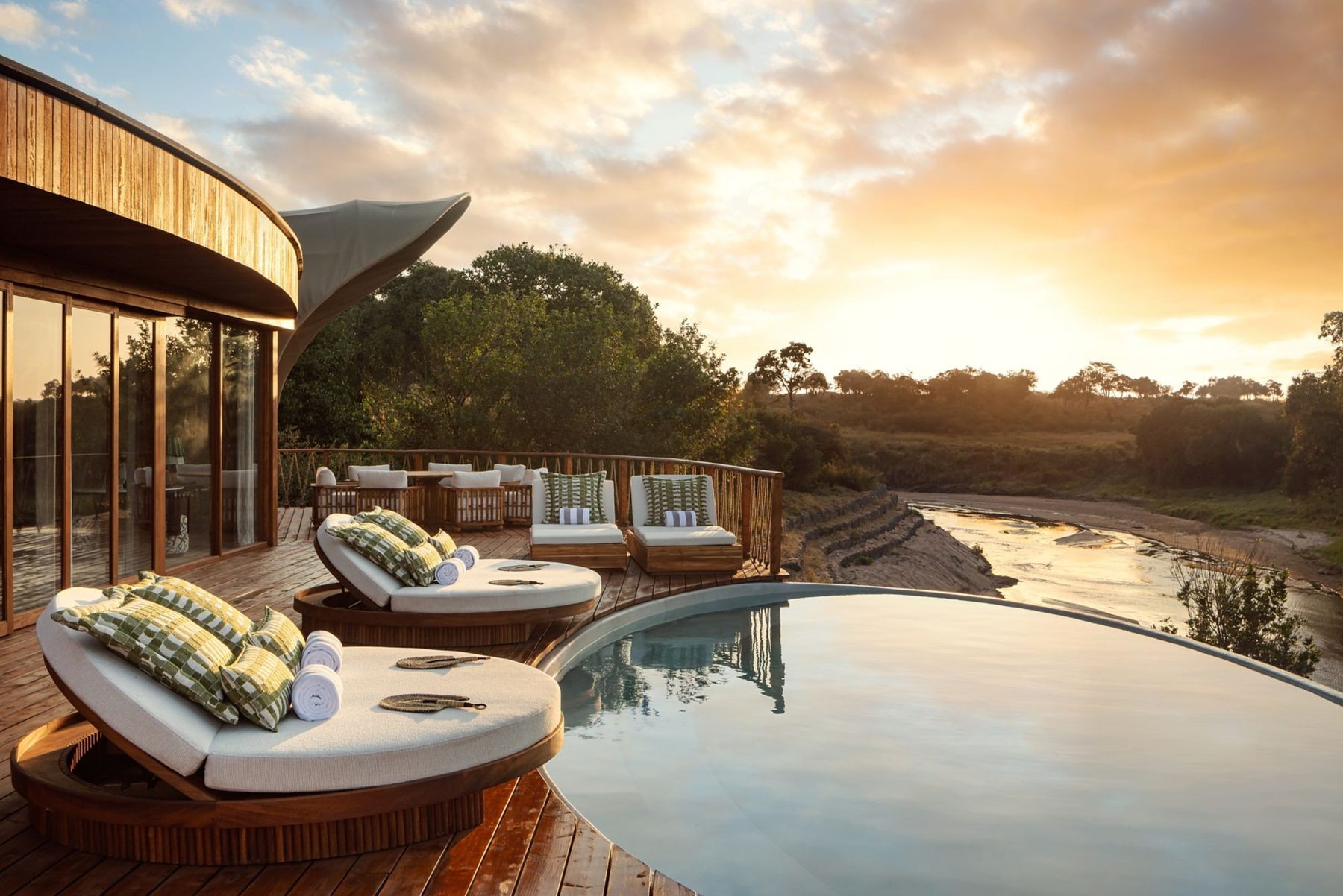 Private plunge pool and cushioned loungers on a suite deck at The Ritz-Carlton, Masai Mara Safari Camp at sunset